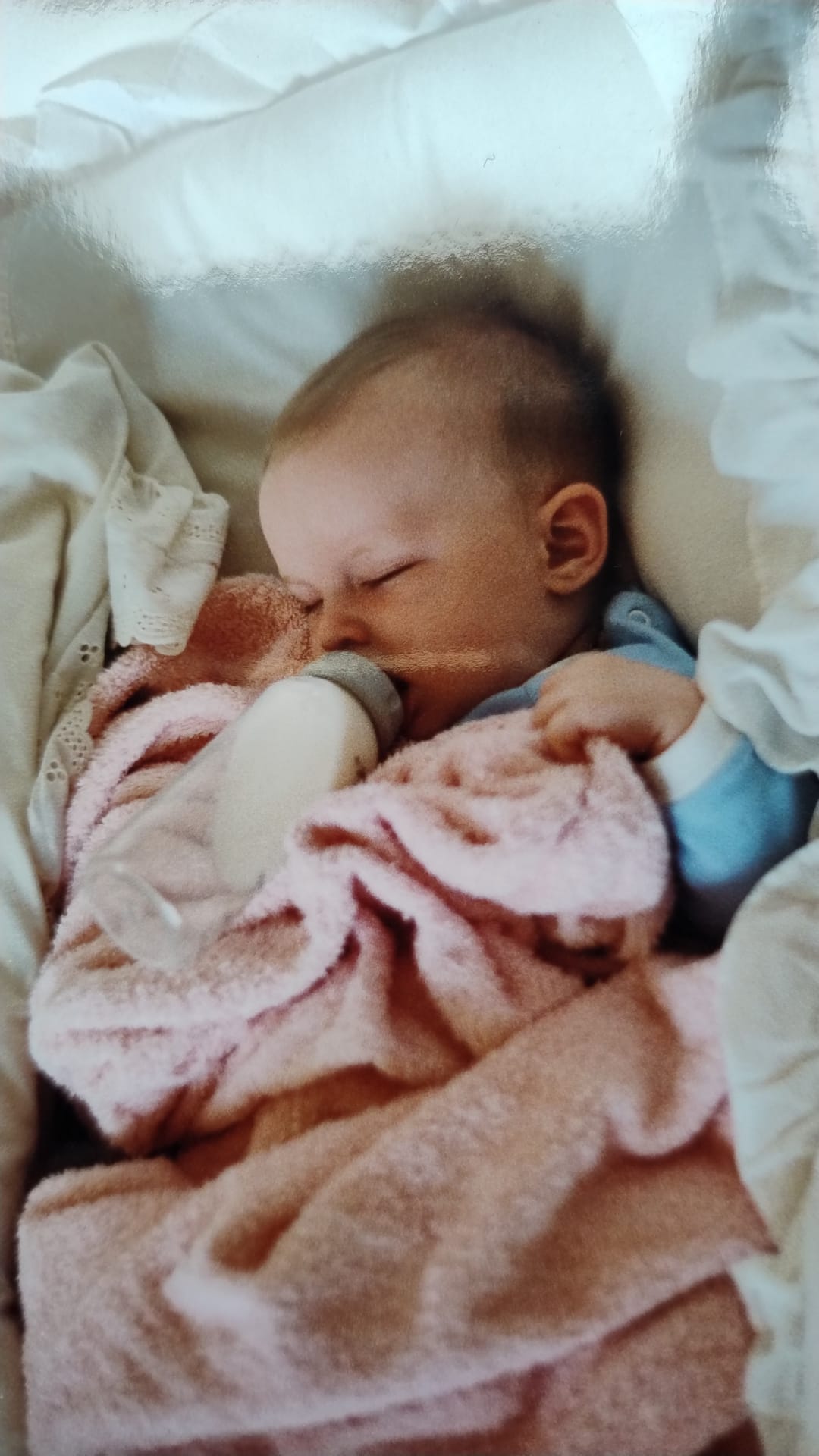 Black and white photo of James Hacking, founder of Socially Powerful, as a newborn baby in 1988, asleep in a cradle with a milk bottle beside him