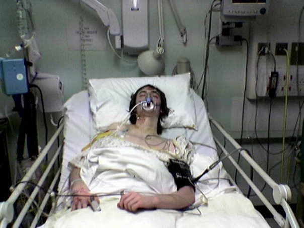 Teenage James Hacking in a hospital bed with an oxygen mask and monitoring lines after his lung collapsed in 2007, the turning point that ended his football career