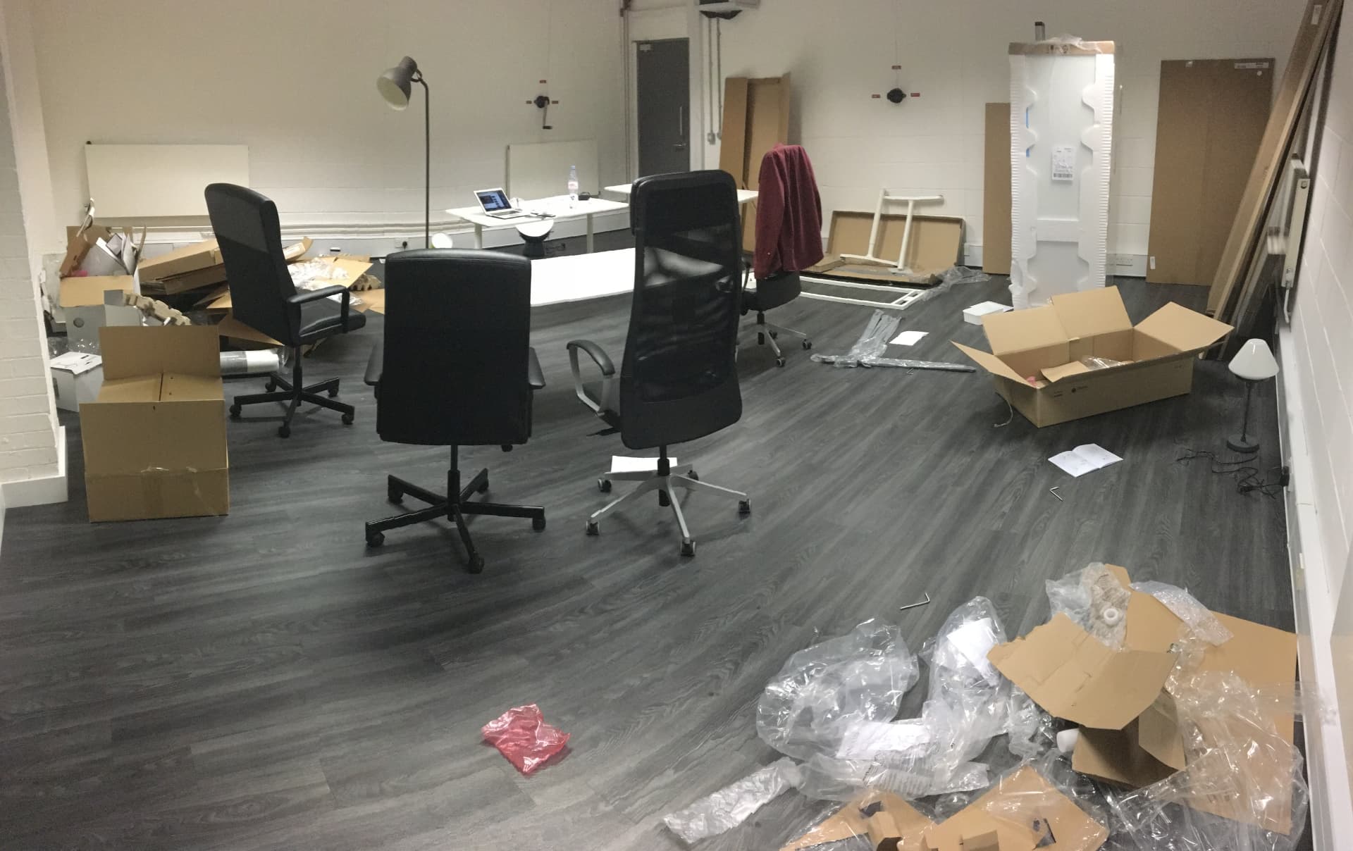Socially Powerful's first office mid move-in, with flat-pack boxes, packaging and office chairs across the floor