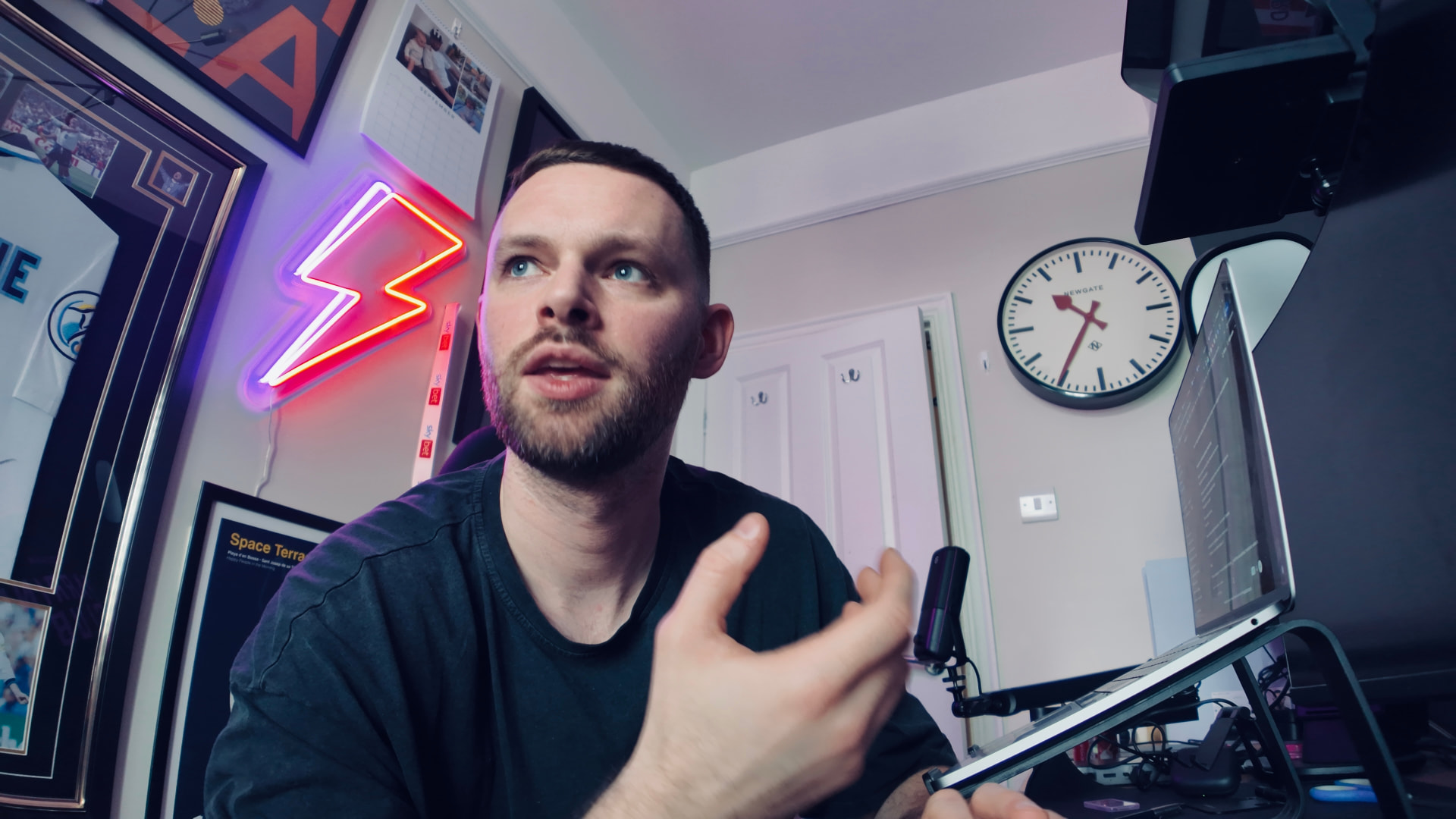 James Hacking mid-vlog at his desk with neon lighting behind him